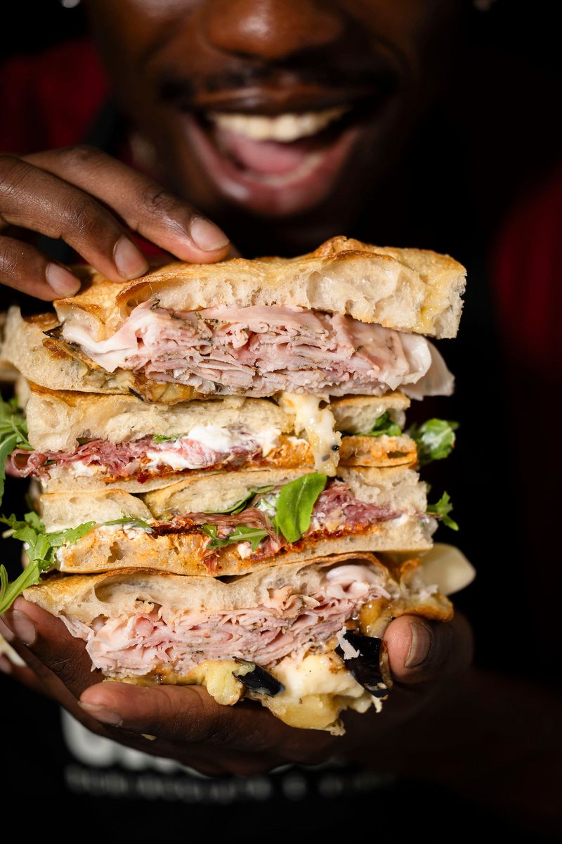 A guest holding a stacked Crosta schiacciata