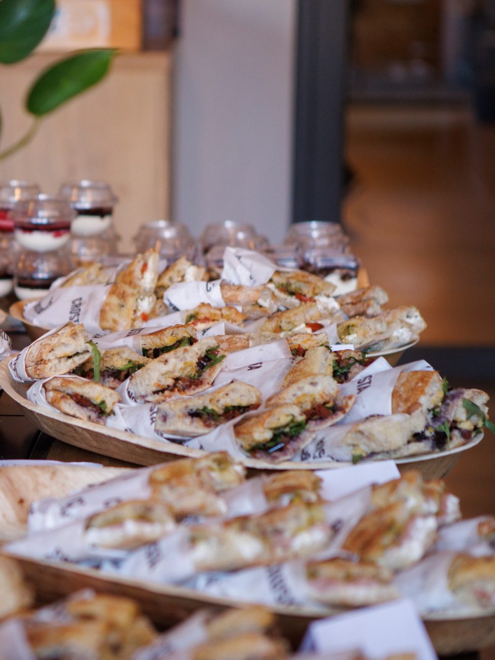 Wooden boards heaped with wrapped schiacciata at a Crosta catering