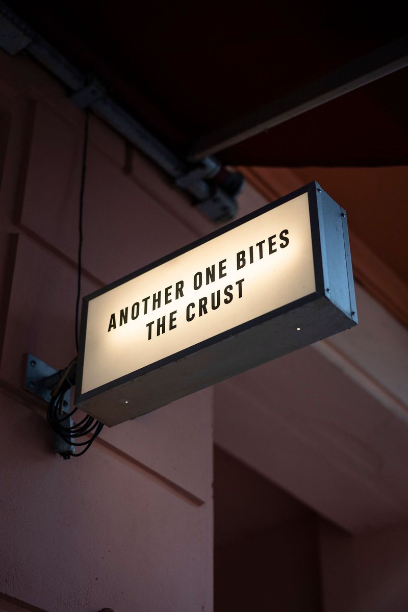 The Crosta hanging sign on Weinbergsweg reading Another One Bites The Crust